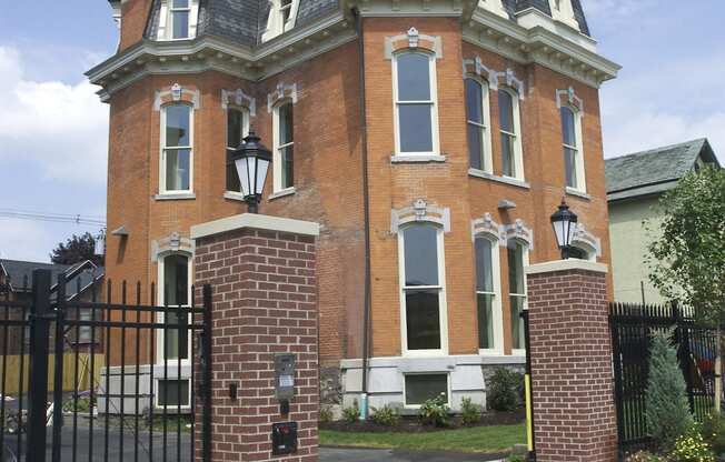 a red brick house with a black wrought iron gate