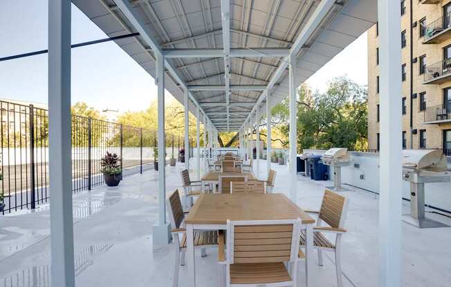 A patio with a table and chairs is covered by a white roof.