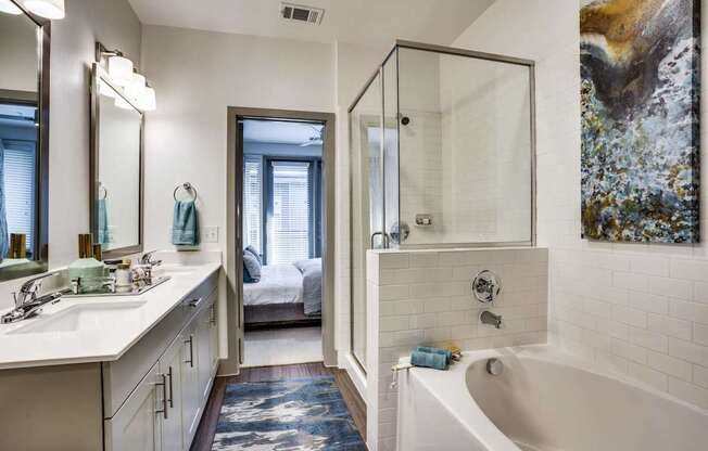 Spa inspired bathroom with shower and tub combo and dual sink vanity at at Midway Urban Village Luxury Townhomes and loft apartments in Farmers Branch, Texas near North Dallas. Luxury North Dallas Tow