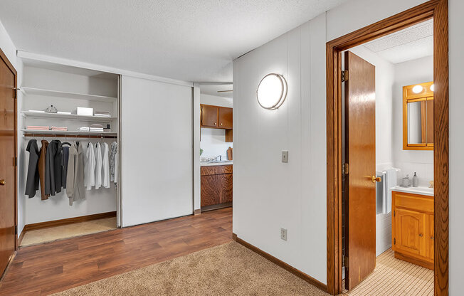 a bathroom with a mirror and a closet with clothes