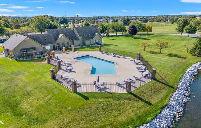 An office and community building with a pool in the back at Oak Shores Apartments in Oak Creek, WI
