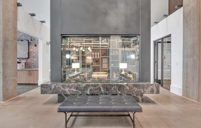 a large glass display case in a lobby with a bench