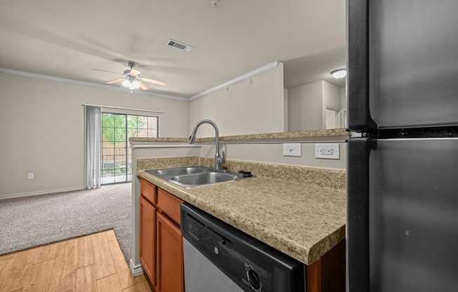 A kitchen with a sink, stove, and refrigerator.