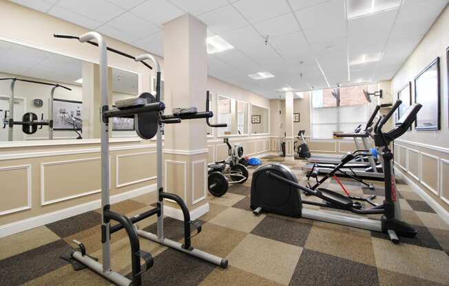 a gym with weights and exercise equipment in the lobby of a building