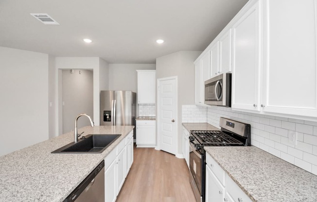 a kitchen with white cabinets and granite countertops