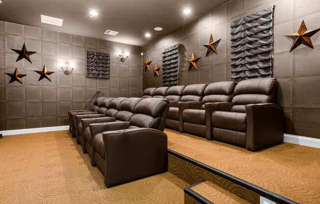 a cinema room with brown leather couches and chairs