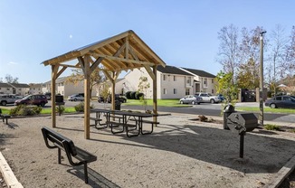 a picnic area with benches and a grill
