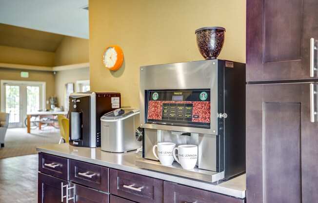 a coffee bar in a hotel room with a coffee machine and coffee cups on the counter