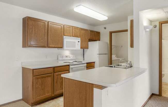 a kitchen with a white counter top and wooden cabinets
