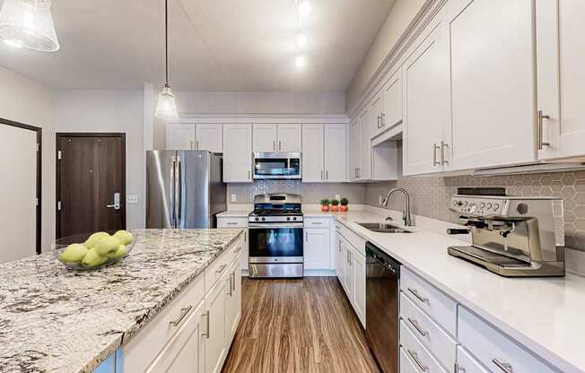 A kitchen with granite countertops and stainless steel appliances.
