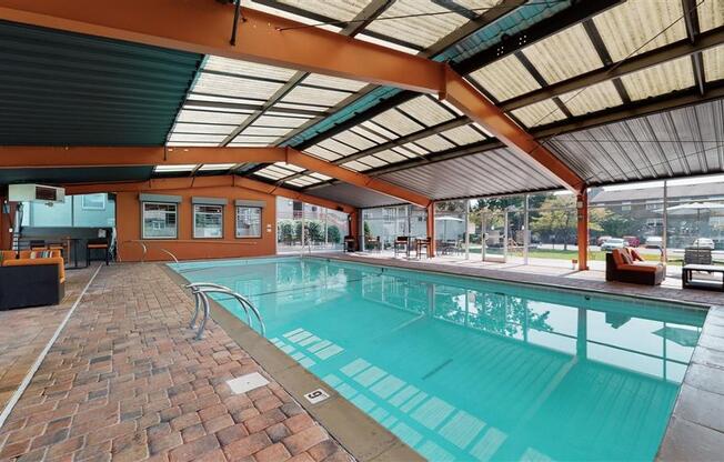 a swimming pool with a ceiling and brick floor