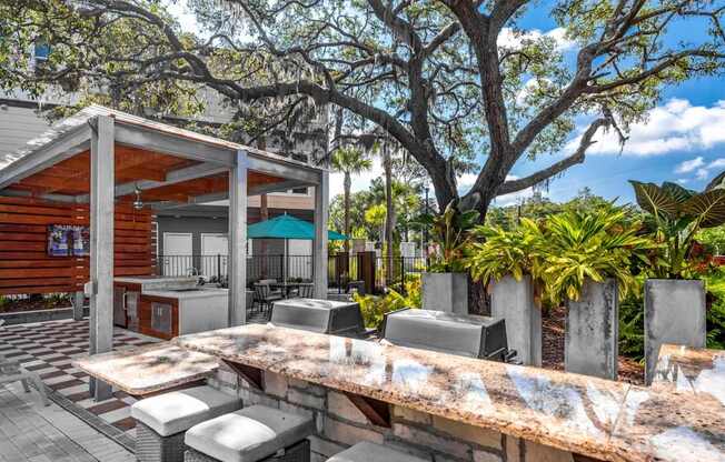 A wooden outdoor kitchen with a grill and sink.