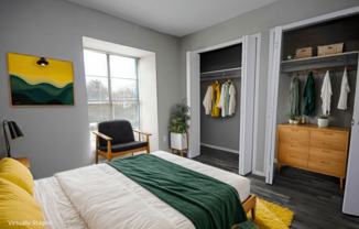 A bedroom with a bed, chair, and wardrobe.