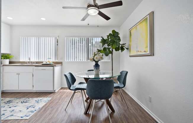 a dining room with a table and chairs and a ceiling fan