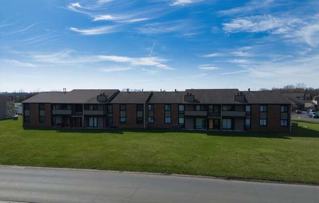 an apartment building on the side of a road with a blue sky