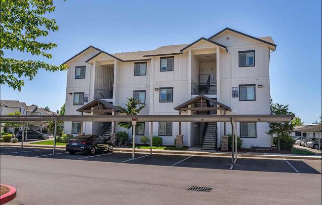 A large white apartment building with a car parked in front at Riverplace Apartment Homes, Oregon, 97351