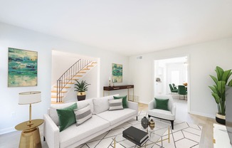 a living room with a white couch and green pillows