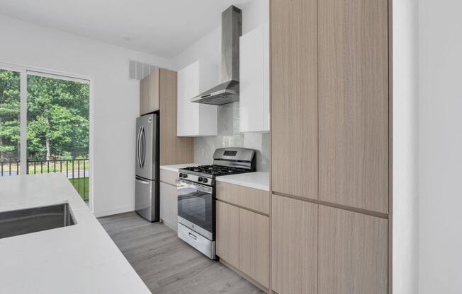 A modern kitchen with wooden cabinets and stainless steel appliances at The Franklin Marlboro Apartments, New Jersey, 07746