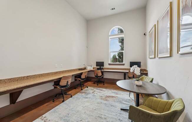 A business center with computers and chairs at Creekside on Parmer Lane Apartments in Austin, TX