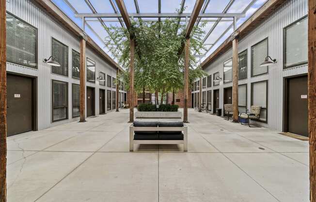 a courtyard with a bench and trees in the middle of it