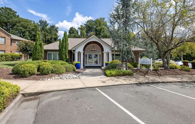 a house with a driveway and trees in the background