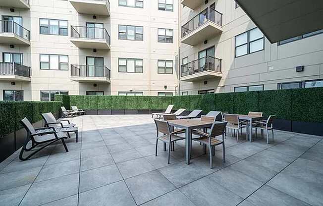 A patio with a table and chairs is in front of a building.