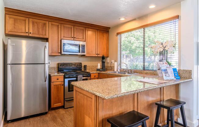 A kitchen with wooden cabinets and a granite countertop.