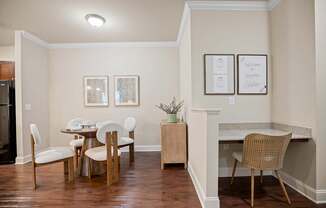 A kitchen with a table and chairs.