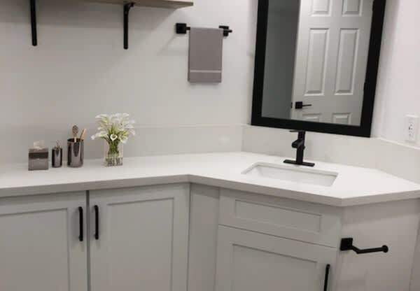 A white bathroom with a sink and a mirror.