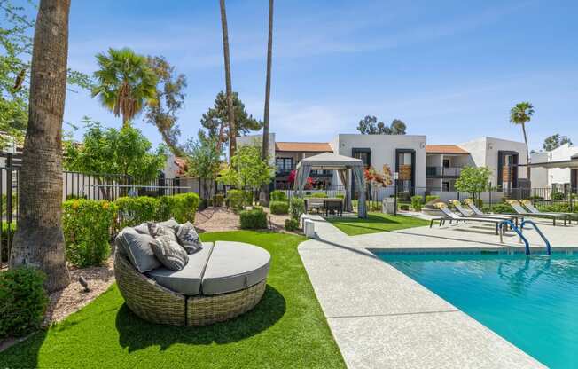 a backyard with a swimming pool and a wicker couch