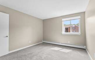 an empty room with carpet and a window