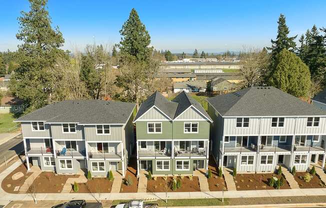 an aerial view of a group of houses with cars parked in front of them