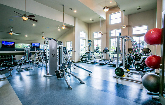 a large fitness room with cardio machines and other exercise equipment