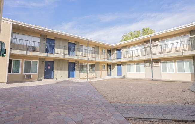 the courtyard of an apartment building with a brick courtyard