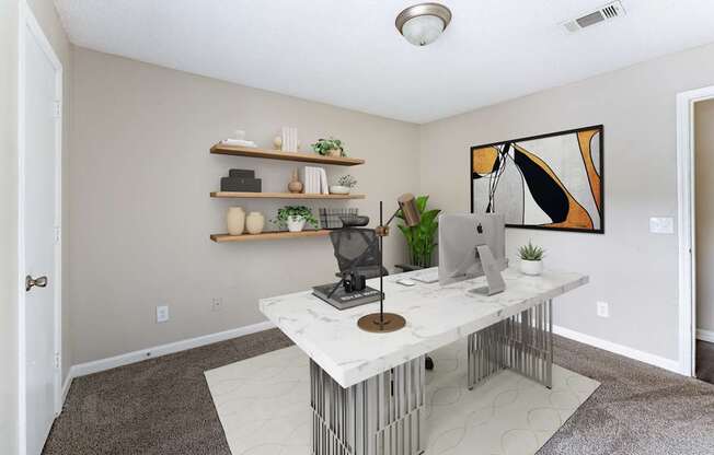 A room with a white desk and a computer on it.
