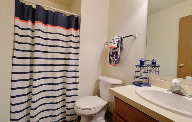 a bathroom with a shower and a sink and a toilet. Fargo, ND Kennedy Apartments