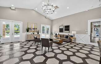 A spacious living room with a patterned floor and a chandelier.