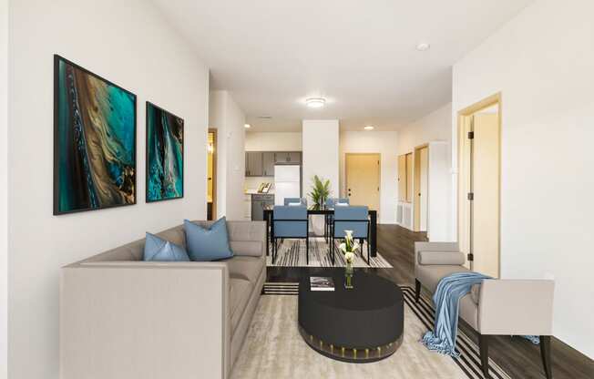 a living room with white walls and wood flooring. Staged with a gray couch, a table and wall art.at Shoreline Village, Richland Washington