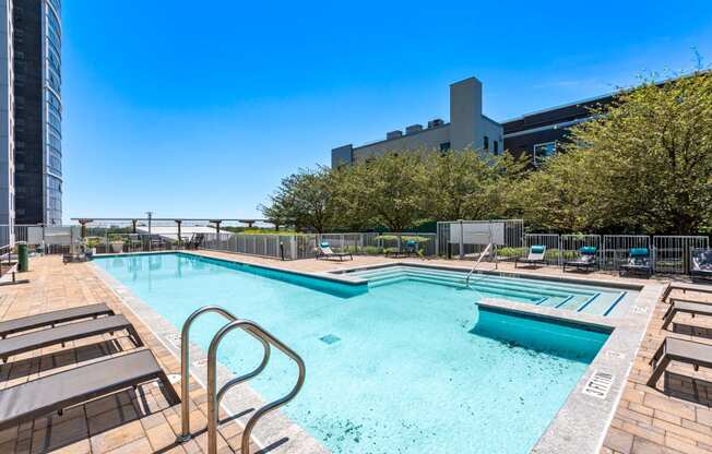 a pool and spa with a building in the background