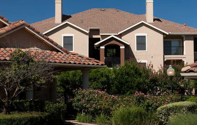 A house with a red tile roof and a white fence.