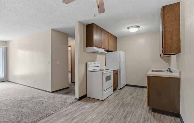 A kitchen area with a white refrigerator, a white oven, and a white dishwasher.