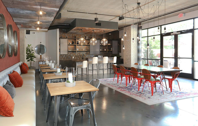 a dining room with tables and chairs and a kitchen in a loft