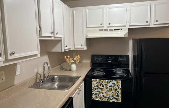 a kitchen with black appliances and white cabinets