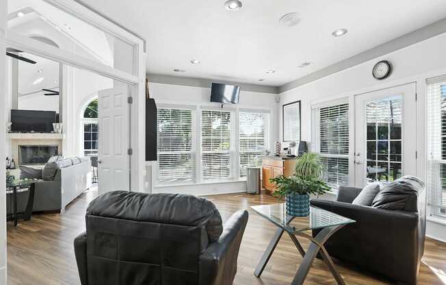 A living room with a black chair and a glass coffee table.
