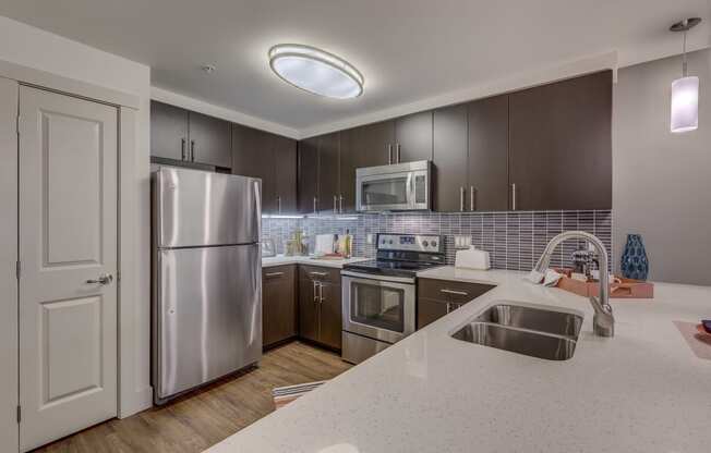 a kitchen with stainless steel appliances and white counter tops