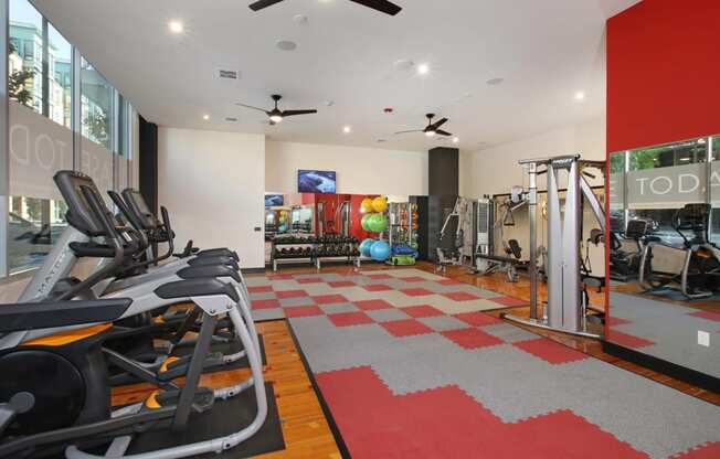 a gym with exercise equipment and a large window