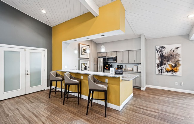 a kitchen and dining area with a yellow accent wall