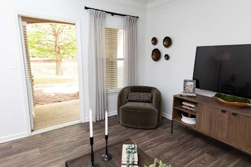 A living room with a chair, a table, and a television.