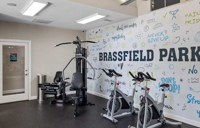 a gym with a white wall with writing on it and exercise equipment