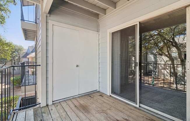 A balcony with a white door and a glass railing.